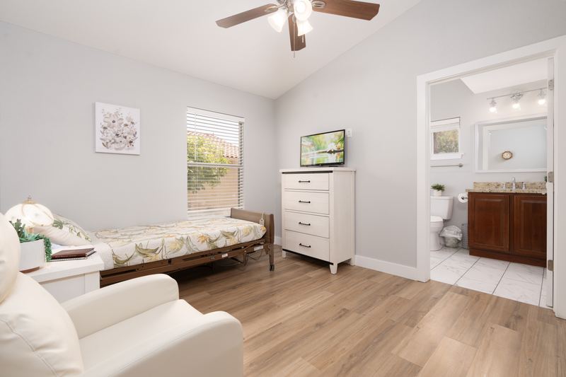 Bedroom with a wall-mounted television, opening onto its own bathroom