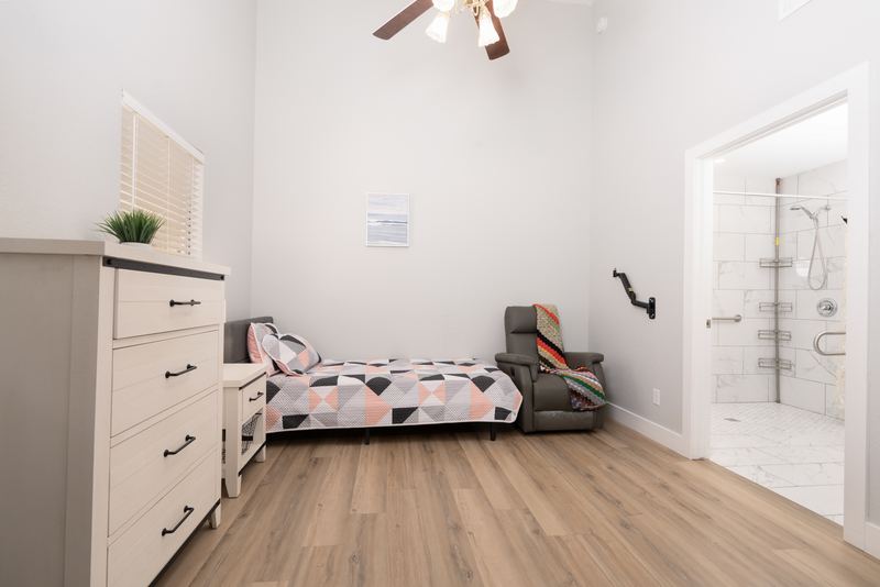 Bedroom with a recliner and a doorway into the walk-in shower